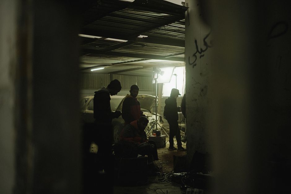 Silhouettes of people working in a dimly lit workshop, creating a moody atmosphere.